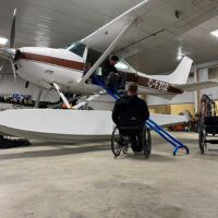 Rick Hansen in Airplane Hanger with his 'Wright Lift' Wheelchair Lift